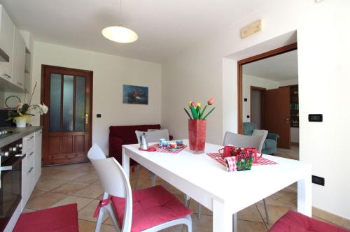 a kitchen and dining room with a white table and chairs at Apartment With Garden, Del Corlo Lake, Belluno in Primolano