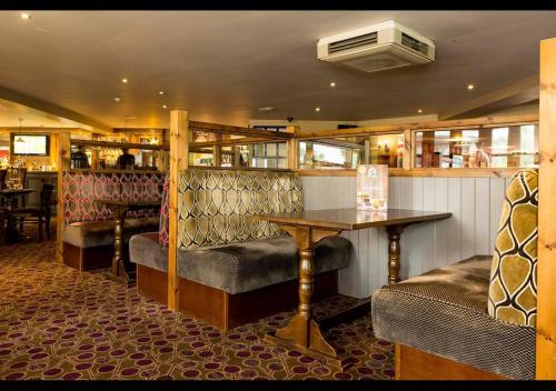 a restaurant with a bar with a table and chairs at 35 Redwood - Beauport Park, Hastings in Hastings