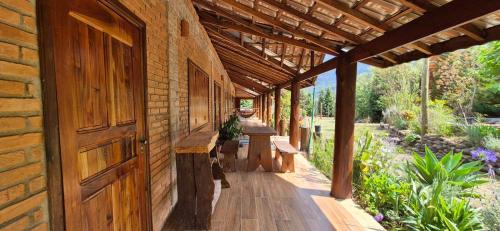 a wooden building with a porch with benches on it at Refúgio Mantiqueira - Parte Alta Parque Nacional Itatiaia in Itamonte