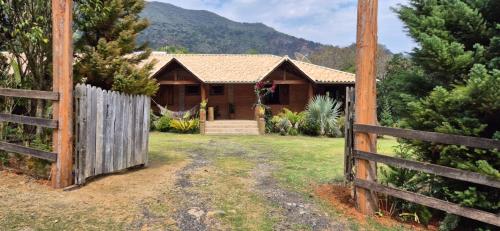 a wooden fence in front of a house at Refúgio Mantiqueira - Parte Alta Parque Nacional Itatiaia in Itamonte