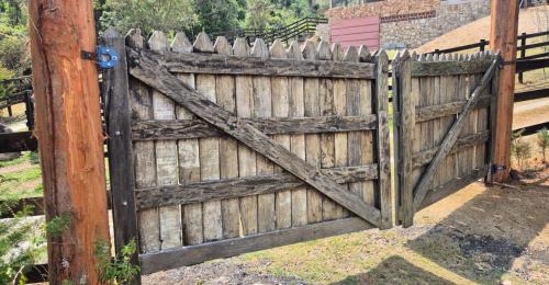 an old wooden fence with a wooden door at Refúgio Mantiqueira - Parte Alta Parque Nacional Itatiaia in Itamonte