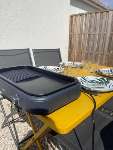une valise assise sur une table jaune dans l'établissement Maisons Martigny B - Proche Futuroscope et Aquascope, à Chasseneuil-du-Poitou