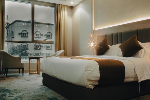 a hotel room with a bed and a large window at Armada Residence Hotel in Taif