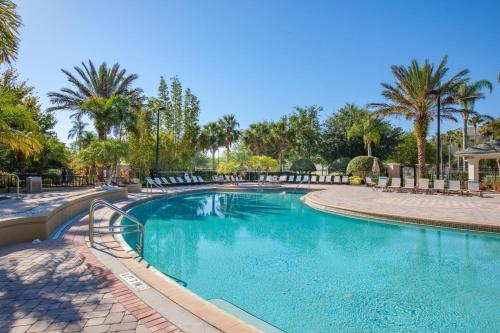 a swimming pool in a resort with palm trees at 3B/3.5B Vista Cay Resort - 5 min from Universal in Orlando