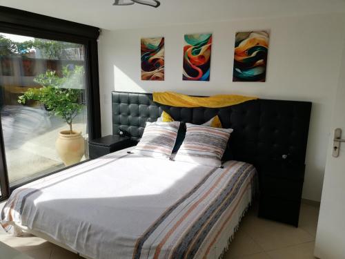 une chambre avec un grand lit et une fenêtre dans l'établissement Appart Sympa au Calme, à Grasse