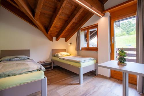 a bedroom with two beds and a window at Ferienwohnungen Zurschmitten in Riederalp