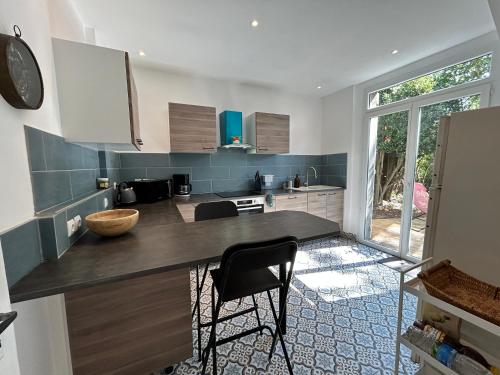 - une cuisine avec un comptoir et des chaises dans l'établissement 1007 Ker Jean Louis - Maison 7p à 300m de la plage, à Pléneuf-Val-André