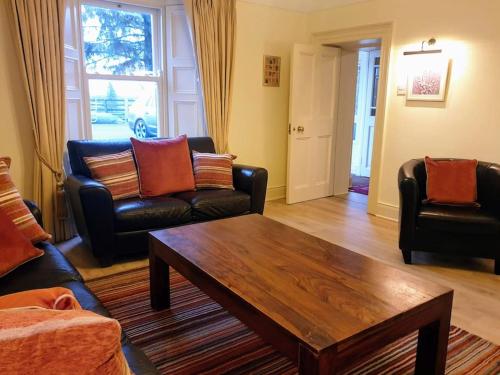 a living room with couches and a coffee table at Period country house set within equestrian centre in Ashford