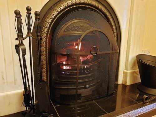 an old fireplace with a fire in it at Period country house set within equestrian centre in Ashford