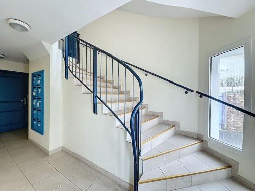 un escalier dans une maison avec une porte bleue dans l'établissement Appartement tout confort proche plage, à Mesquer