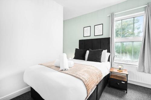 une chambre avec un grand lit et une fenêtre dans l'établissement Three Bed House - Accommodates 7 - Parking - Garden - Harborne 465H, à Birmingham