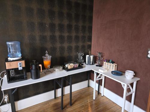 una mesa blanca con una cafetera encima en La Villa Santina, en Rethel