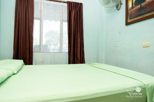 Una cama o camas en una habitación de Manuel Antonio Hostel
