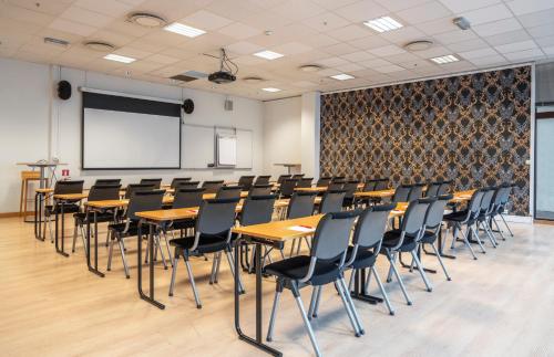 a lecture room with tables and chairs and a whiteboard at Thon Partner Hotel Kristiansand in Kristiansand