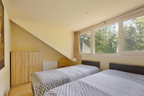 a bedroom with two beds and a window at 't Laankholt in Bornerbroek