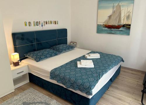 a bedroom with a blue bed with two towels on it at Retro room-Otok Vis in Podstražje