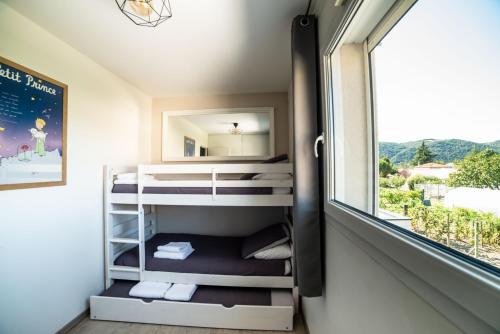 a small room with bunk beds and a window at La Maison de Jade & Spa in La Roche-de-Glun
