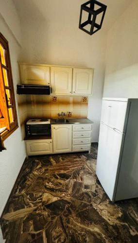 a kitchen with white cabinets and a refrigerator at Medusa apartments in Amoudara Herakliou