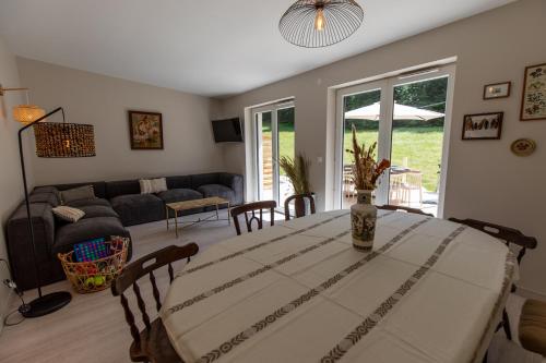 a living room with a table and a couch at Gîte La Résilience, sur la piste de ski d'Autrans in Autrans