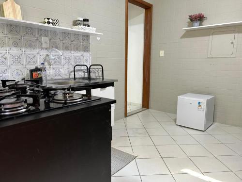 a kitchen with a stove and a refrigerator at Mansão Adalgisa Suíte com Ar Próximo Cidade de Deus Jaguaré e Butantã in Osasco