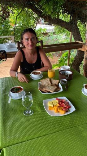 a woman sitting at a table with a plate of food at Ceylon Beach haven Uppuveli in Trincomalee