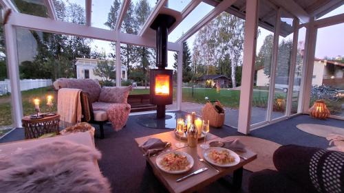 a large conservatory with a table with candles on it at Villa It's Arctic Magic! in Rovaniemi
