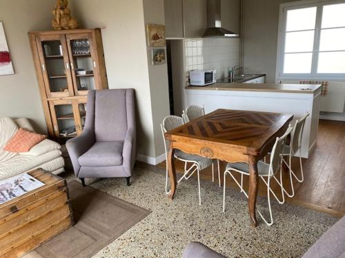 une cuisine avec une table et des chaises dans une pièce dans l'établissement Le clin d'oeil de la vallée, à Ambrief