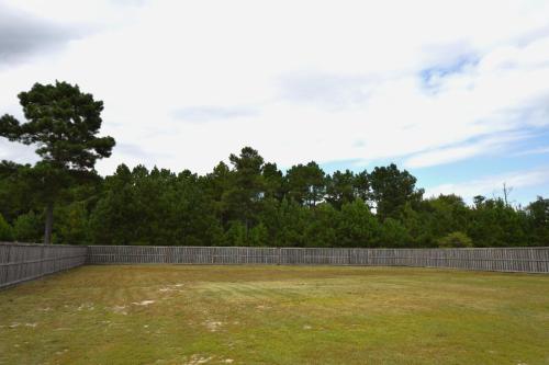 a large yard with a fence and trees at Peytons Ridge - entire house near Camp Lejeune and beaches in Hubert