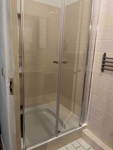 a shower with a glass door in a bathroom at The Rotterdam Suite in Rotterdam