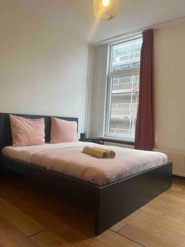 a bed sitting in a room with a window at The Rotterdam Suite in Rotterdam