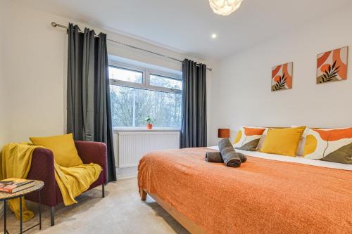 a bedroom with a bed and two chairs and a window at Warm & Cosy, Pet-friendly Home in Worsley