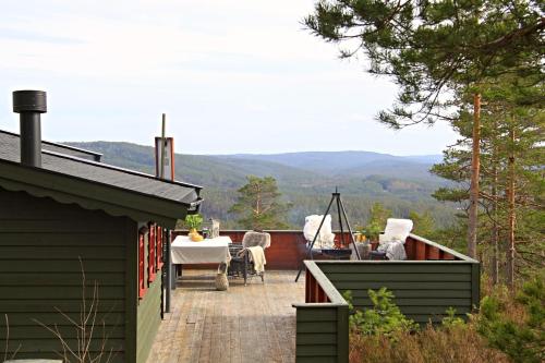 a patio with a table and chairs on top of a house at Cozy cottage with a wonderful view - Hiking trails - Silence in Mjåvatn