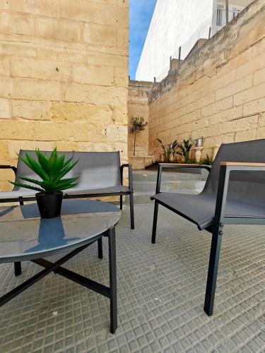 two chairs and a table and a potted plant on a patio at Cosy room 4 in Pieta