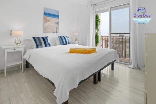 1 dormitorio blanco con 1 cama blanca grande y balcón en Casa Estrella Marina del Este, en La Herradura