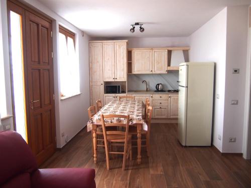 Una cocina con una mesa y un refrigerador blanco. en Roncola 2021, en Roncola