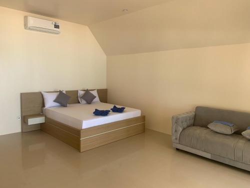 un dormitorio con una cama y un sofá en Bluecoral Bungalows, en Gili Meno