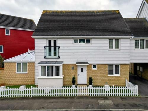 a white house with a white picket fence at Charming Essex Hideaway in Southend-on-Sea