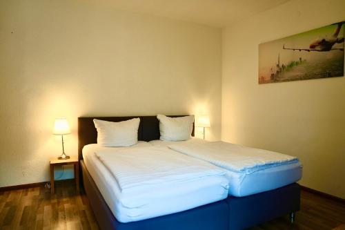 a bedroom with a bed with white sheets and pillows at Burghotel Lörrach in Lörrach