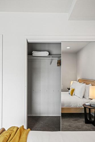 a bedroom with a bed and a glass door with a mirror at Littlefield Lofts, Hosted by Placemakr - 6th St in Austin