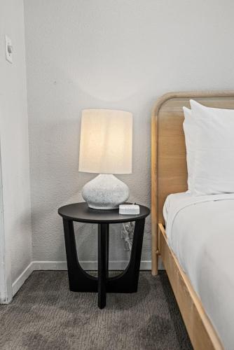 a table with a lamp on it next to a bed at Littlefield Lofts, Hosted by Placemakr - 6th St in Austin
