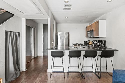 a kitchen with two bar stools and a counter top at Littlefield Lofts, Hosted by Placemakr - 6th St in Austin