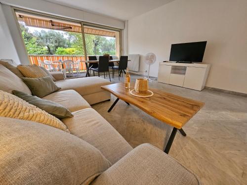 un salon avec un canapé et une table dans l'établissement Luxueux Appartement 3 pièces, à Antibes