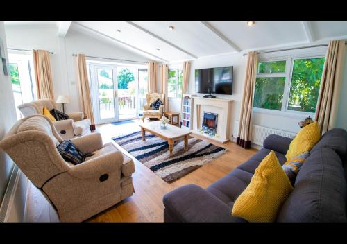 a living room with a couch and chairs and a fireplace at 11 The Oaks - Lodge - Coghurst Hall - Hastings in Westfield