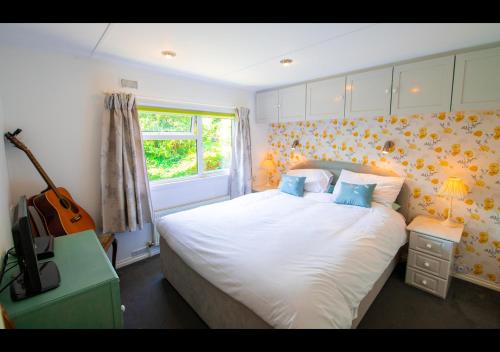 a bedroom with a bed and a guitar in it at 11 The Oaks - Lodge - Coghurst Hall - Hastings in Westfield