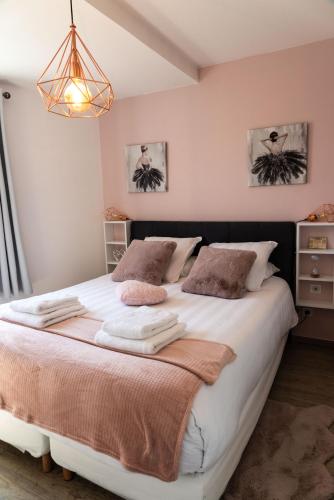 a bedroom with a large bed with towels on it at La Maison de Jade & Spa in La Roche-de-Glun