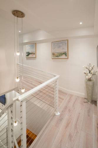 a white staircase in a room with paintings on the wall at Modern Marvel at University City in Philadelphia