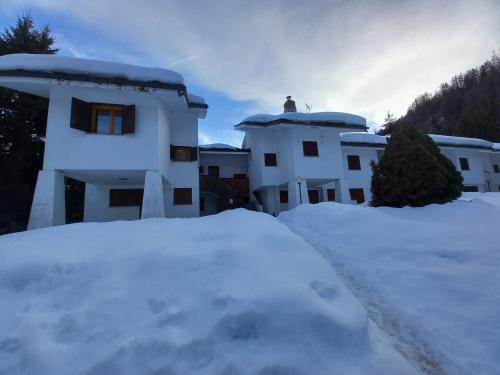 a pile of snow in front of a building at Chez Umbus, centrale e immerso nel verde, grande terrazzo in Champoluc