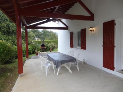 d'une terrasse avec une table et des chaises sous un auvent. dans l'établissement Gure ametsa, à Saint-Étienne-de-Baïgorry
