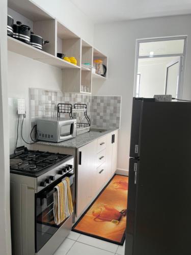 Una cocina con estufa y refrigerador negro. en Comfort Home Two Bedroom Buxton point Mombasa, en Mombasa