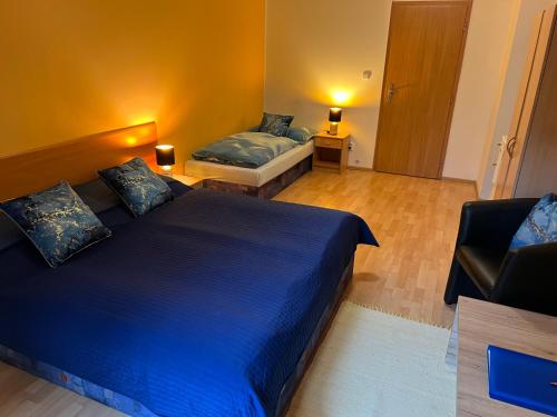 a bedroom with two beds and a chair at Ubytovani Nikol in Brno